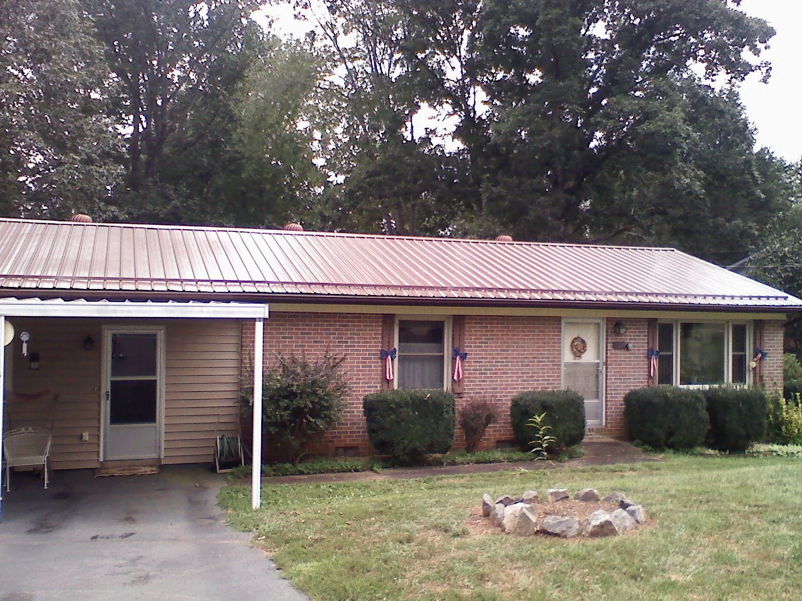 Bronze metal roof and carport on a brick ranch home — Roof Repair work by our crew in Pascagoula