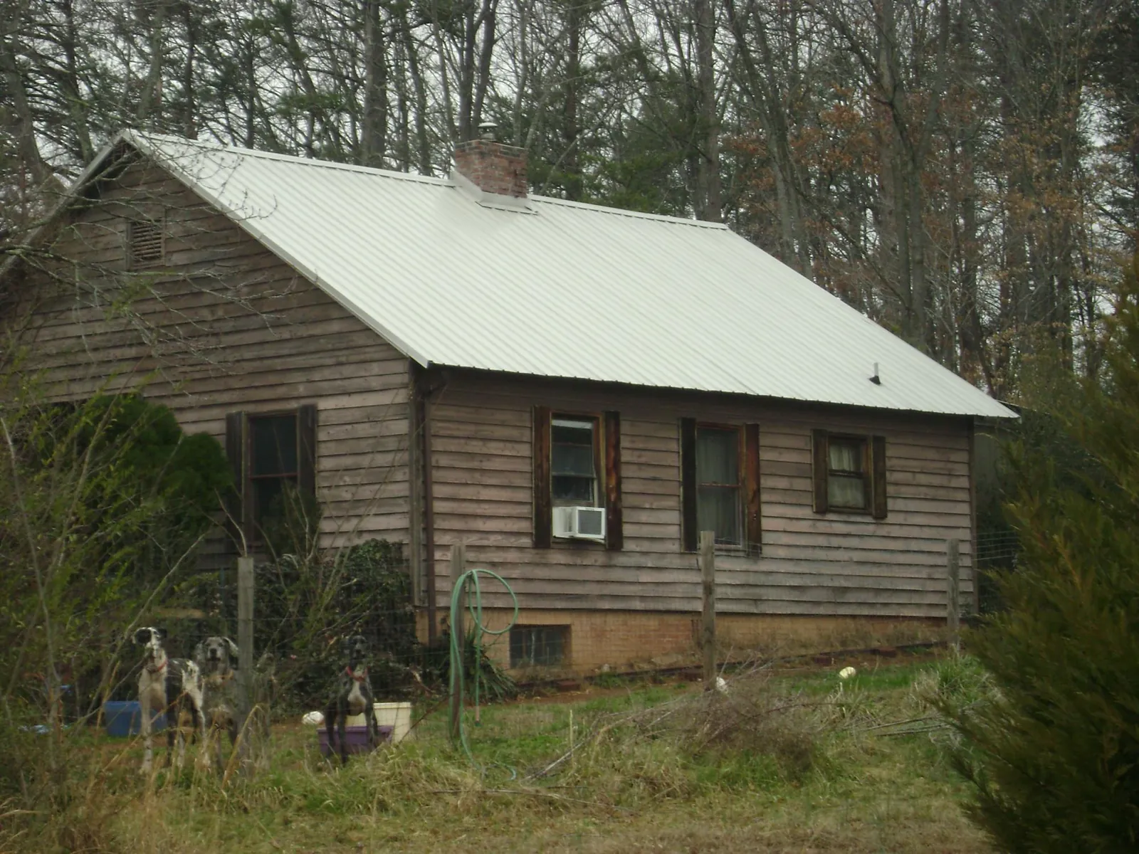 White metal roof on an old wood sided farmhouse, from a Metal Roof Installation job in Pascagoula